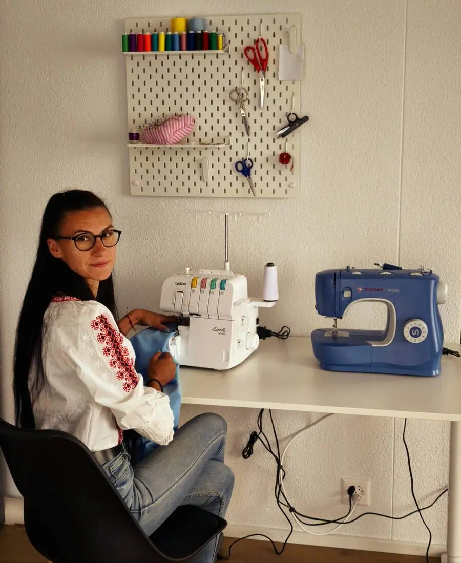 Roxana an ihrem Nähplatz mit Overlock und Nähmaschine